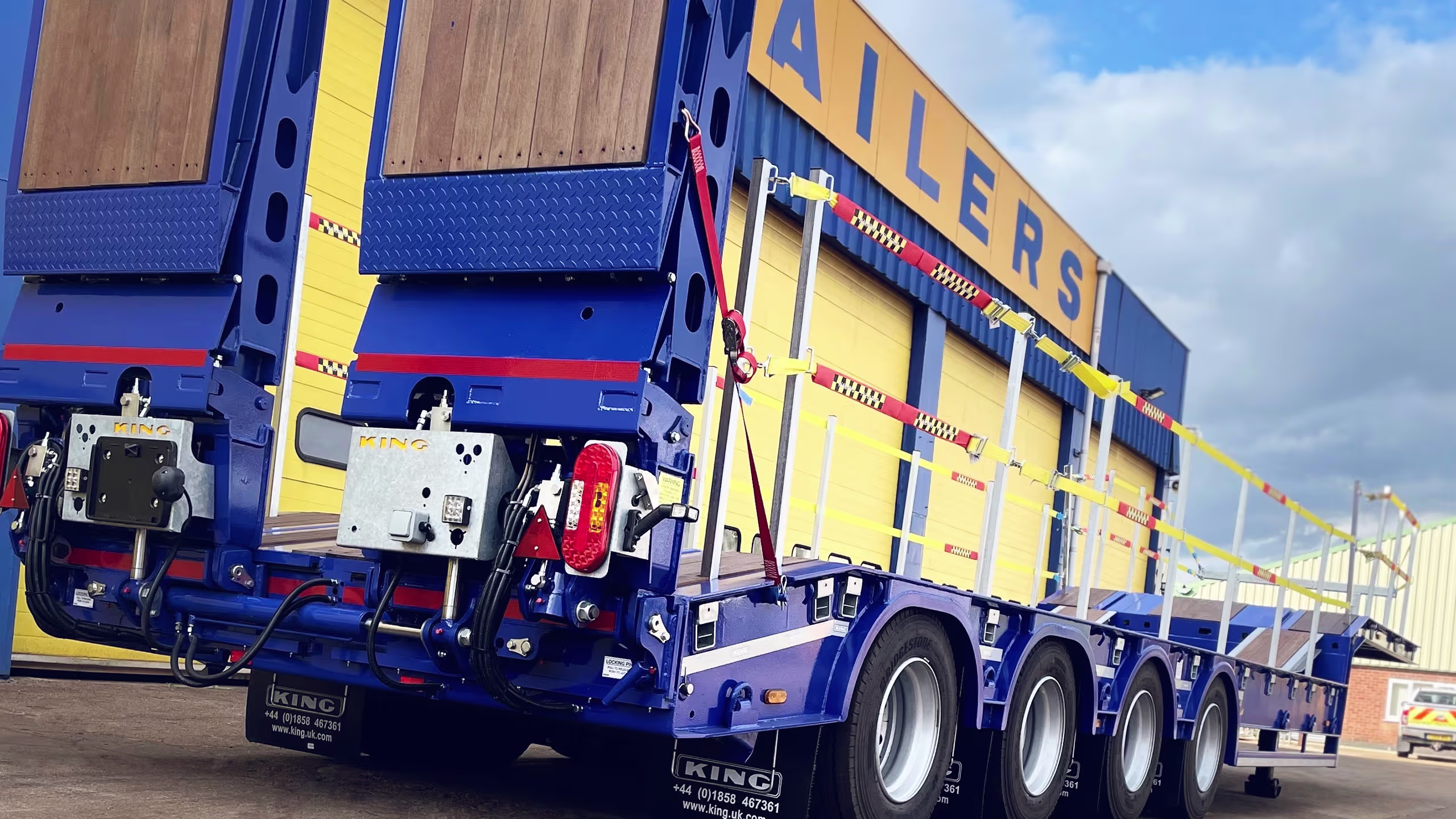 King GTS73/4-19.5 stepframe low loader trailer with hydraulic flip-toe ramps and side rave furniture.