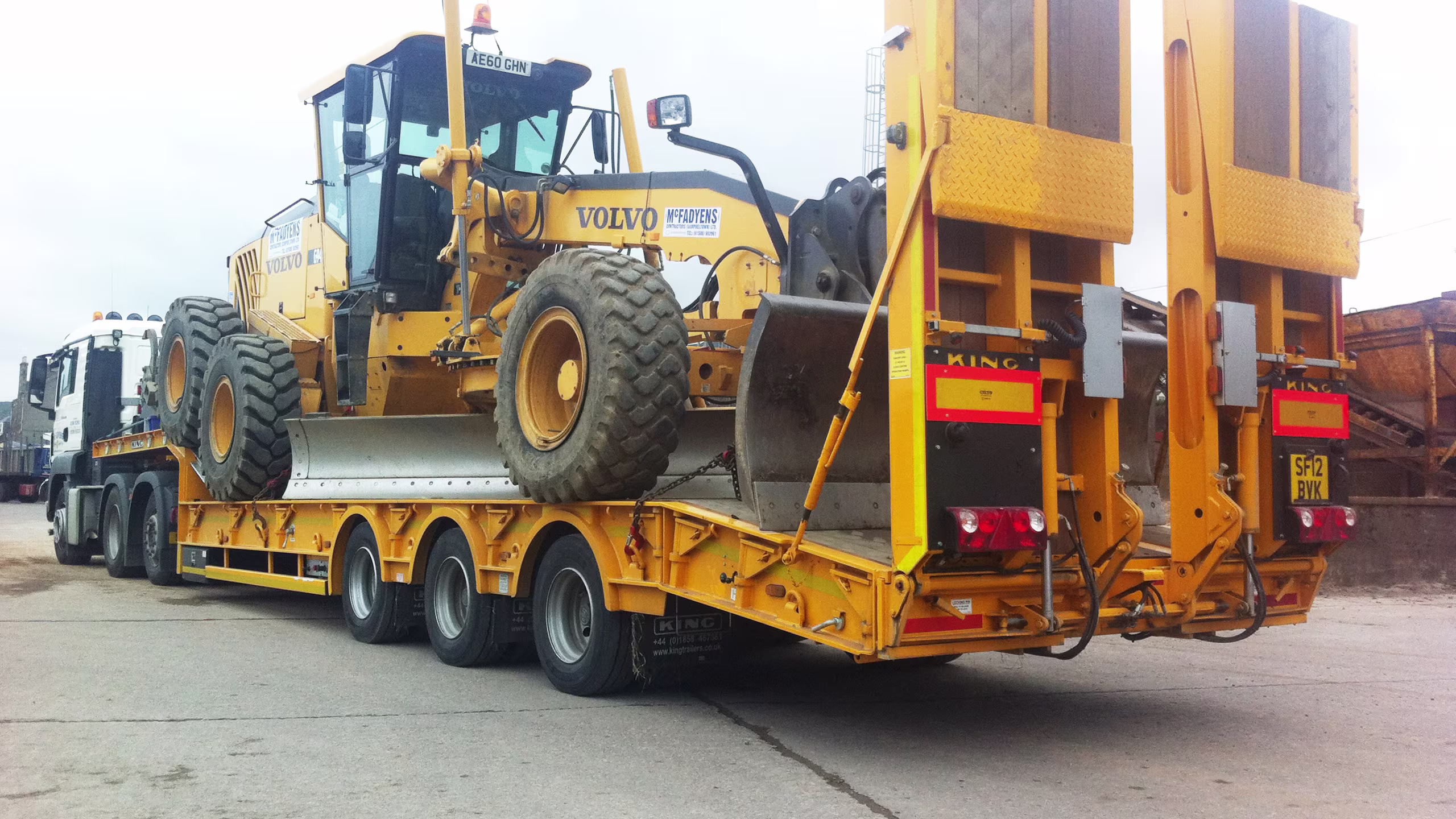 King GTS60 stepframe trailer transporting a Volvo wheel loader, designed for heavy payloads and STGO Category 2 regulations.