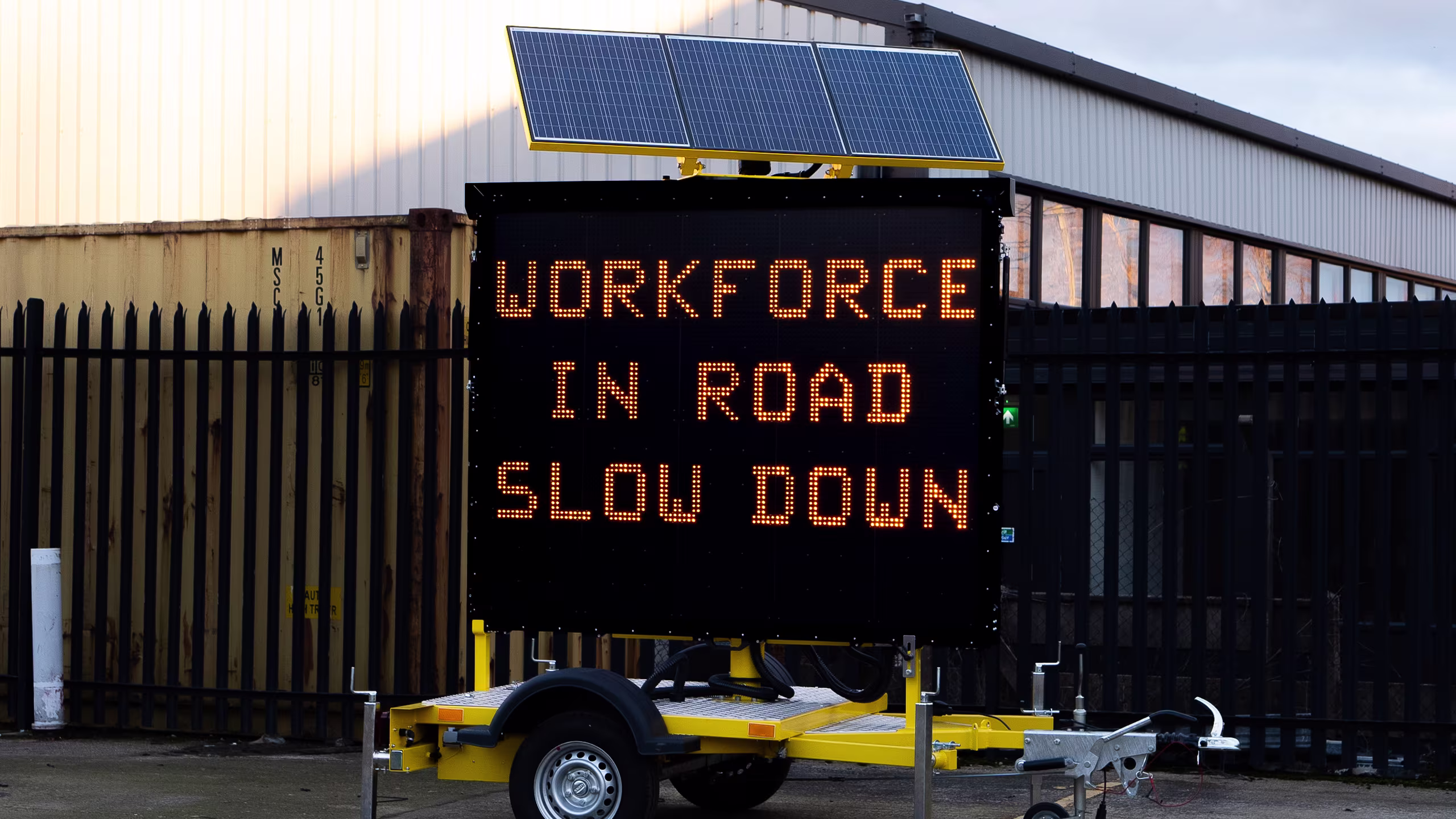 King AVMS VMS trailer displaying "WORKFORCE IN ROAD SLOW DOWN" with solar panels for dependable variable message signage.
