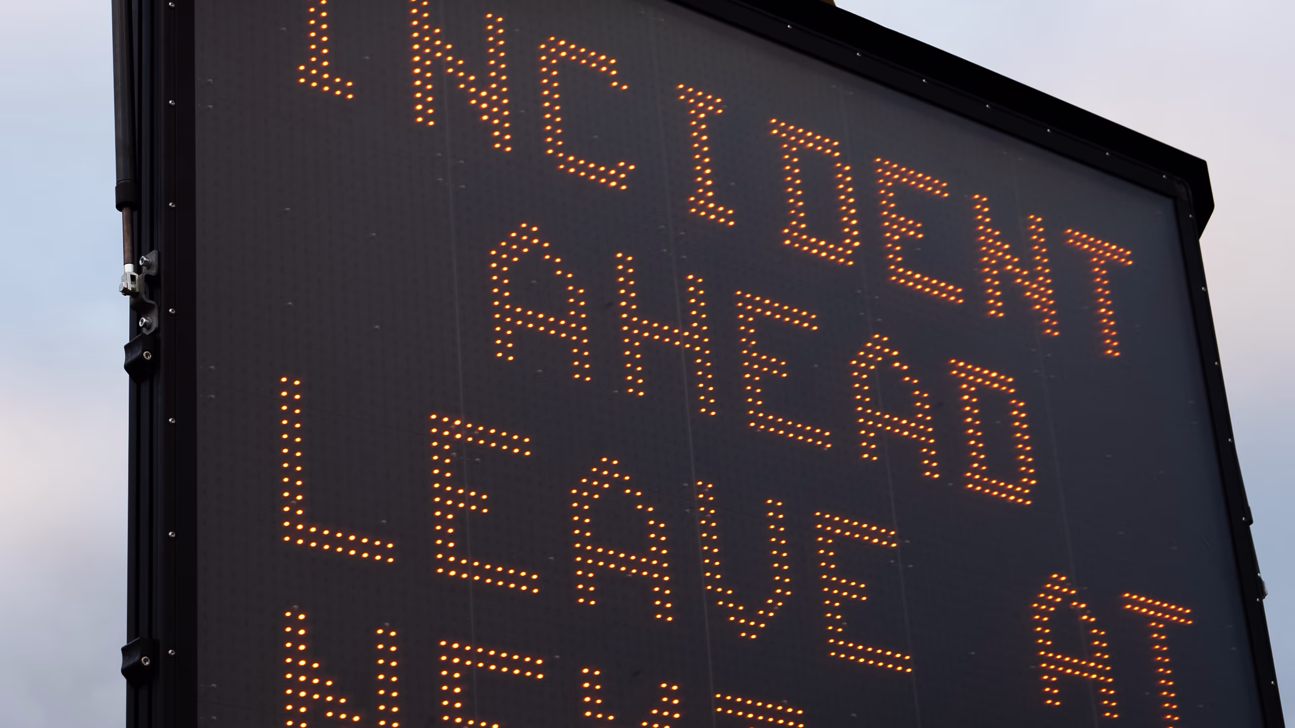 Variable message sign displaying "INCIDENT AHEAD LEAVE AT NEXT AT" for traffic management.
