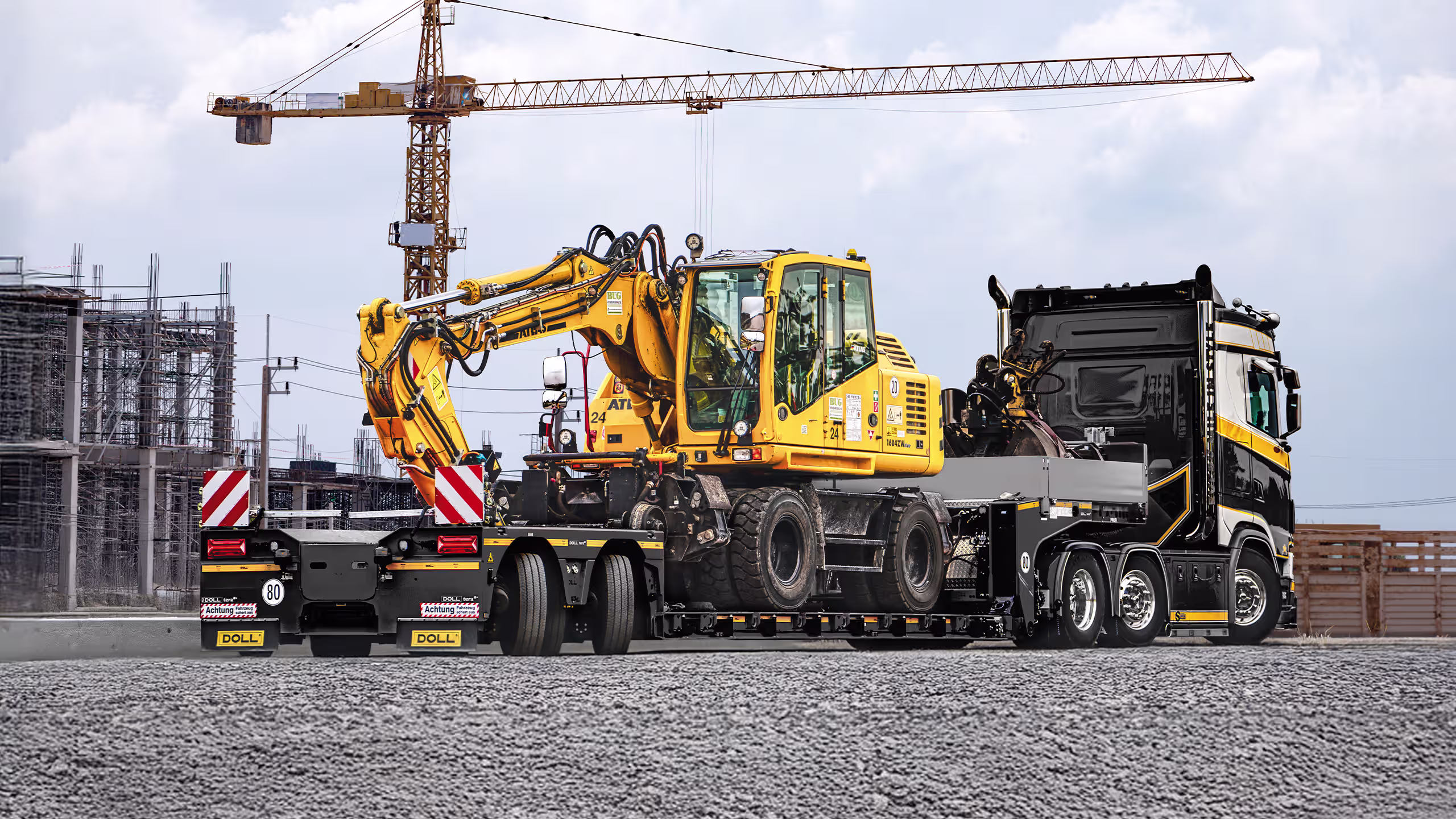 DOLL 2 Axle Lowloader trailer transporting heavy machinery and construction equipment.